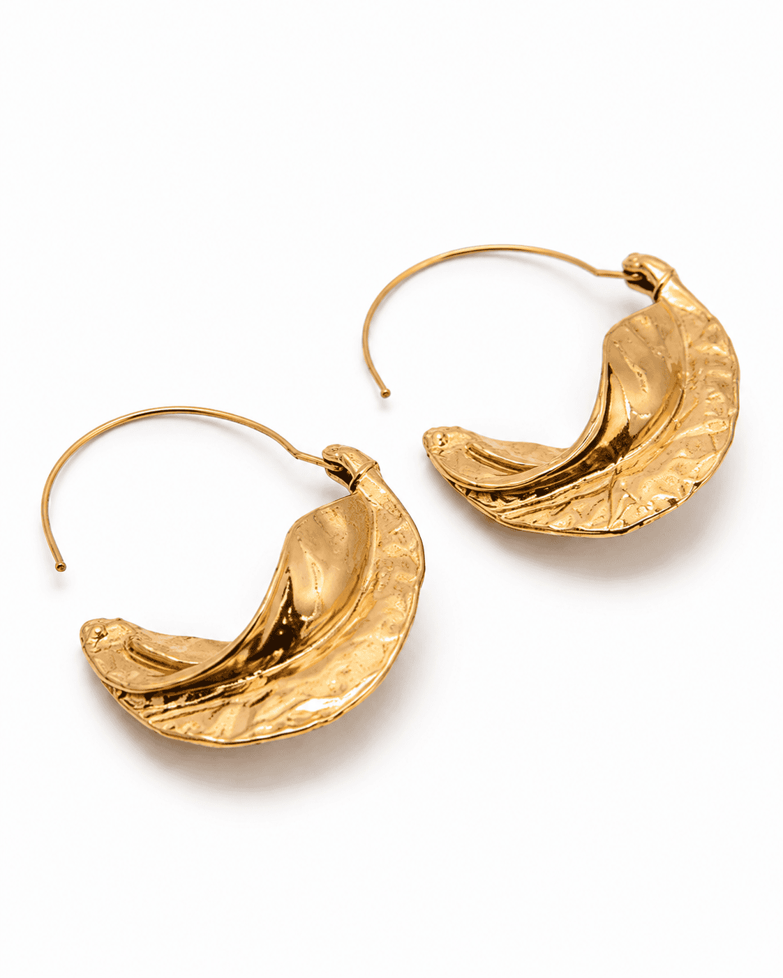 Angled view of AMALFI gold-tone hammered crescent basket hoops showing the fine pull-through wire