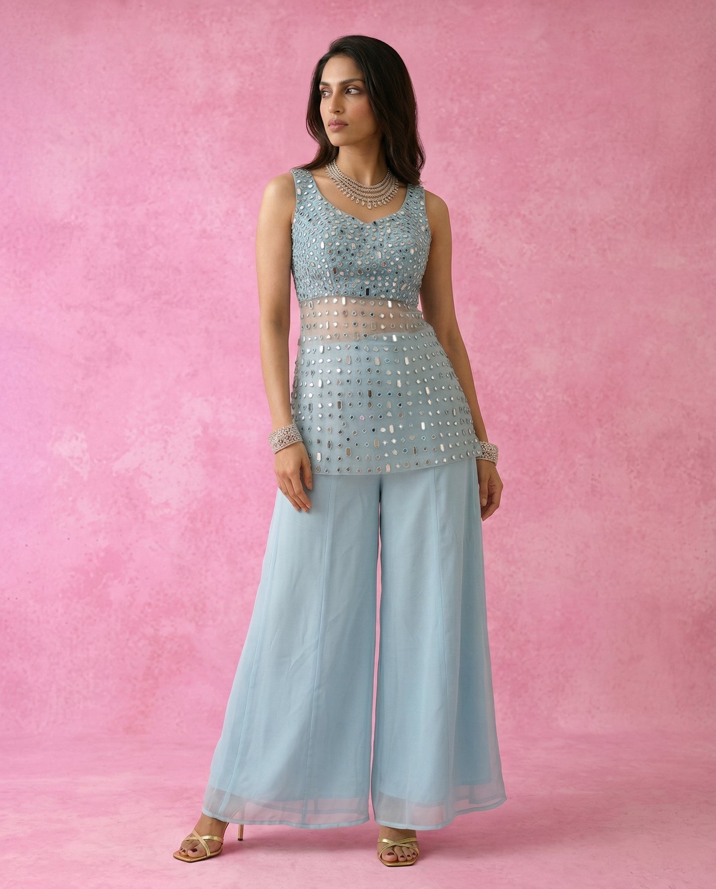 Front view of the MAHTAB short mirror work kurta over the flowing powder blue sharara pants.