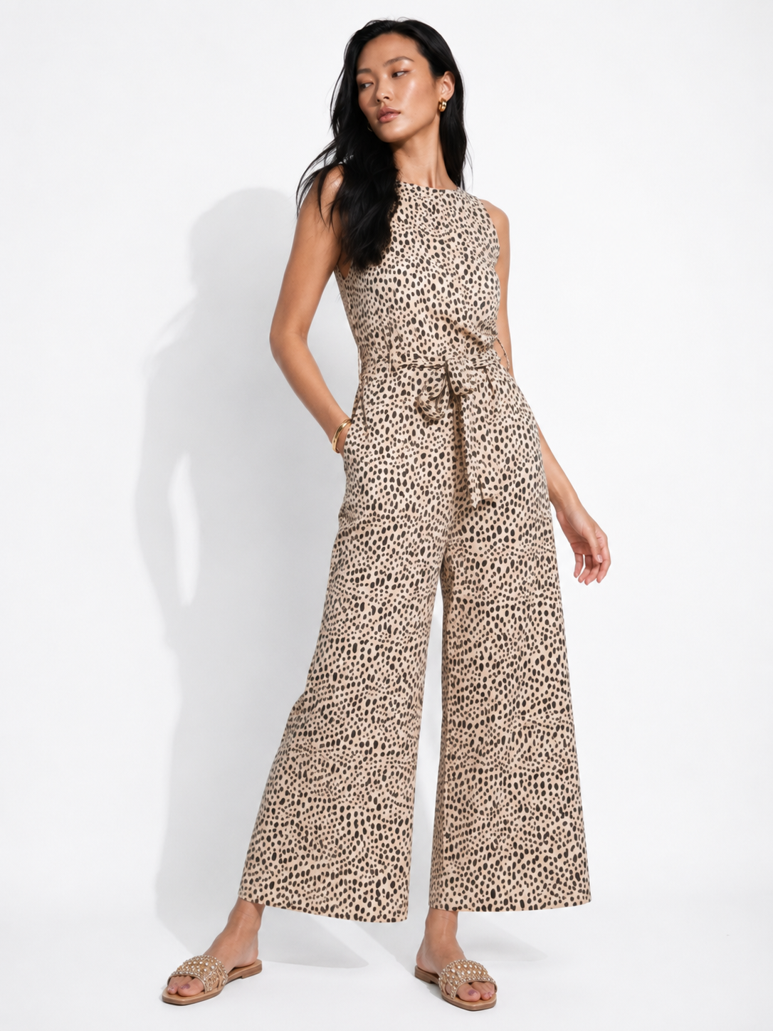 HAZEL cheetah print jumpsuit with hand in the side pocket.