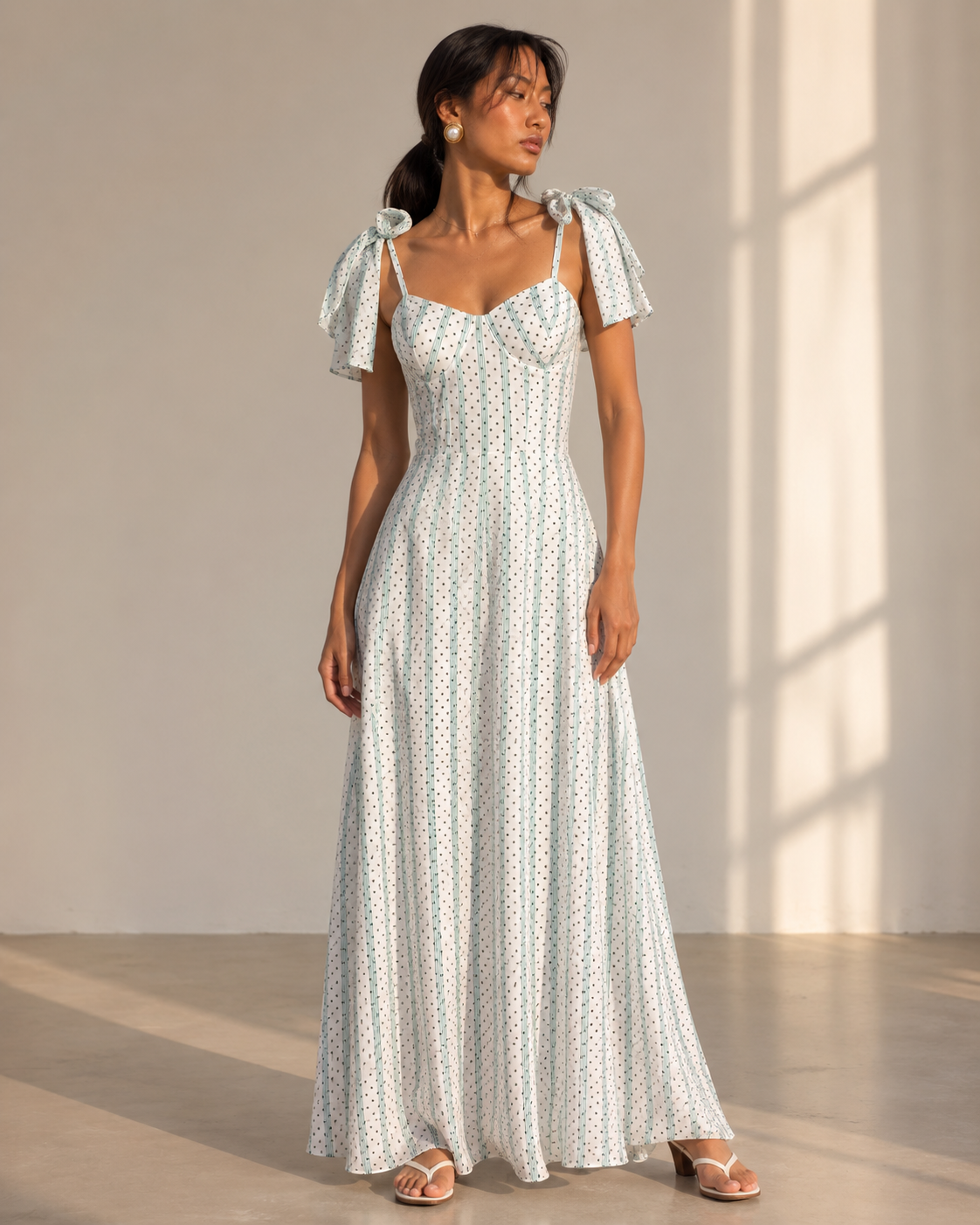 Model wearing SYLVIE white corset maxi dress with mint stripes and black dots by Neha Sharma Label.