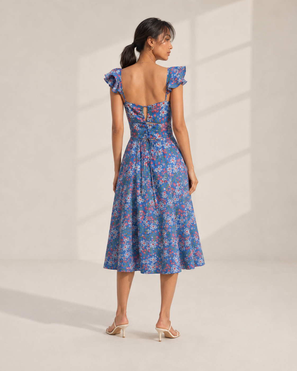 Detail of the white daisy and coral floral print on ROMY's cornflower blue fabric.