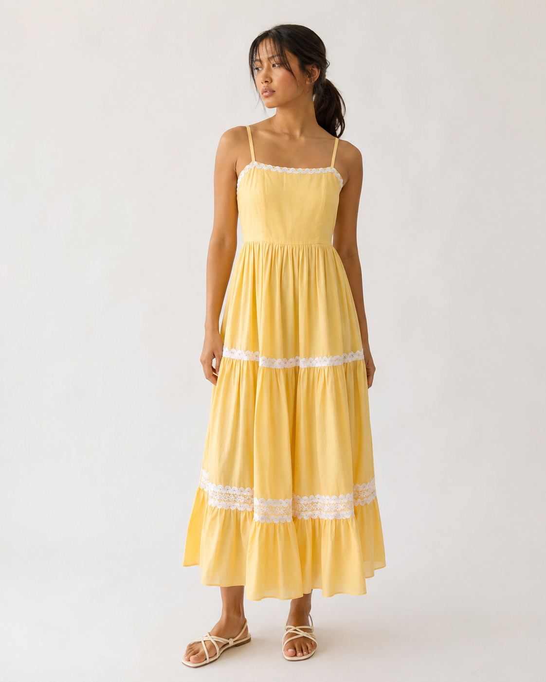 Model wearing JUNE butter yellow tiered lace-trim maxi dress by Neha Sharma Label.