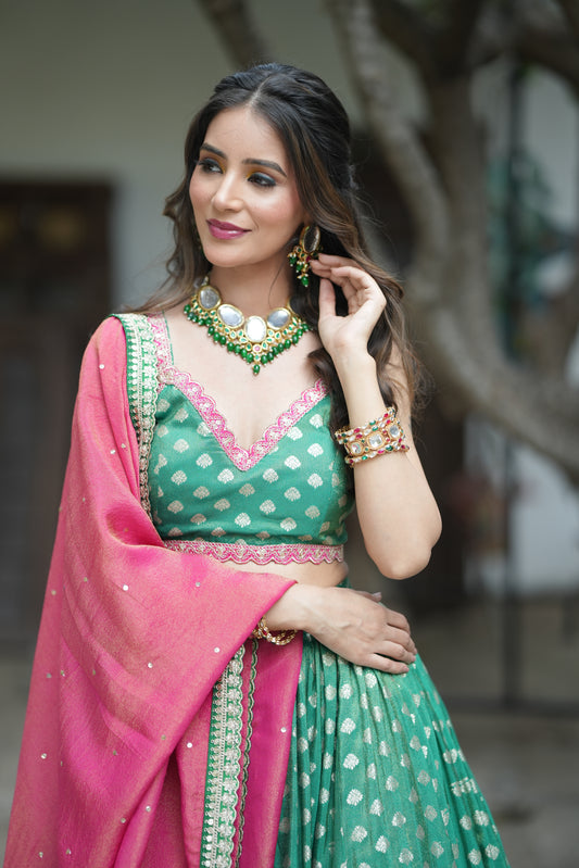Traditional green Banarasi lehenga paired with a crop top designer blouse design.