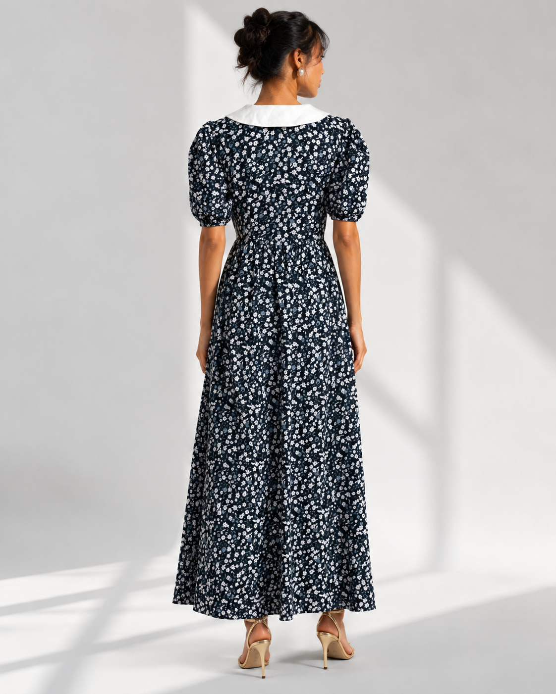 Back view of the EULALIE navy ditsy floral maxi dress showing the collar and gathered skirt.