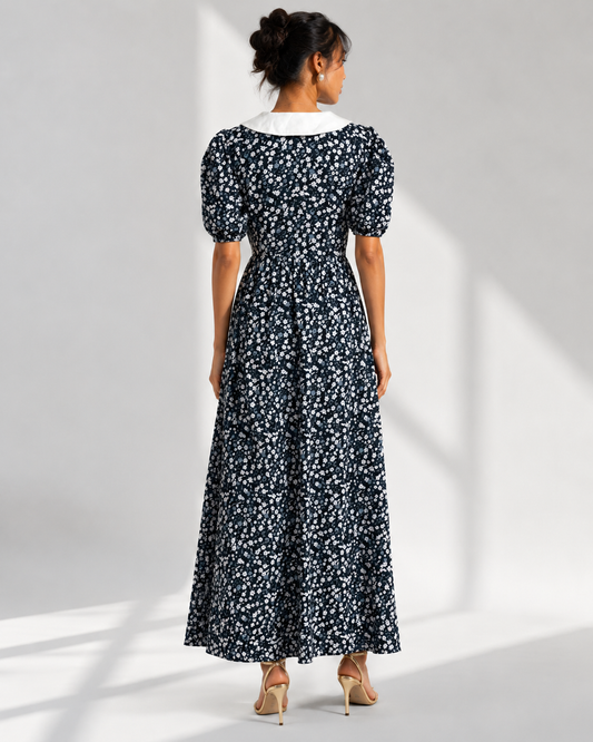 Back view of the EULALIE navy ditsy floral maxi dress showing the collar and gathered skirt.