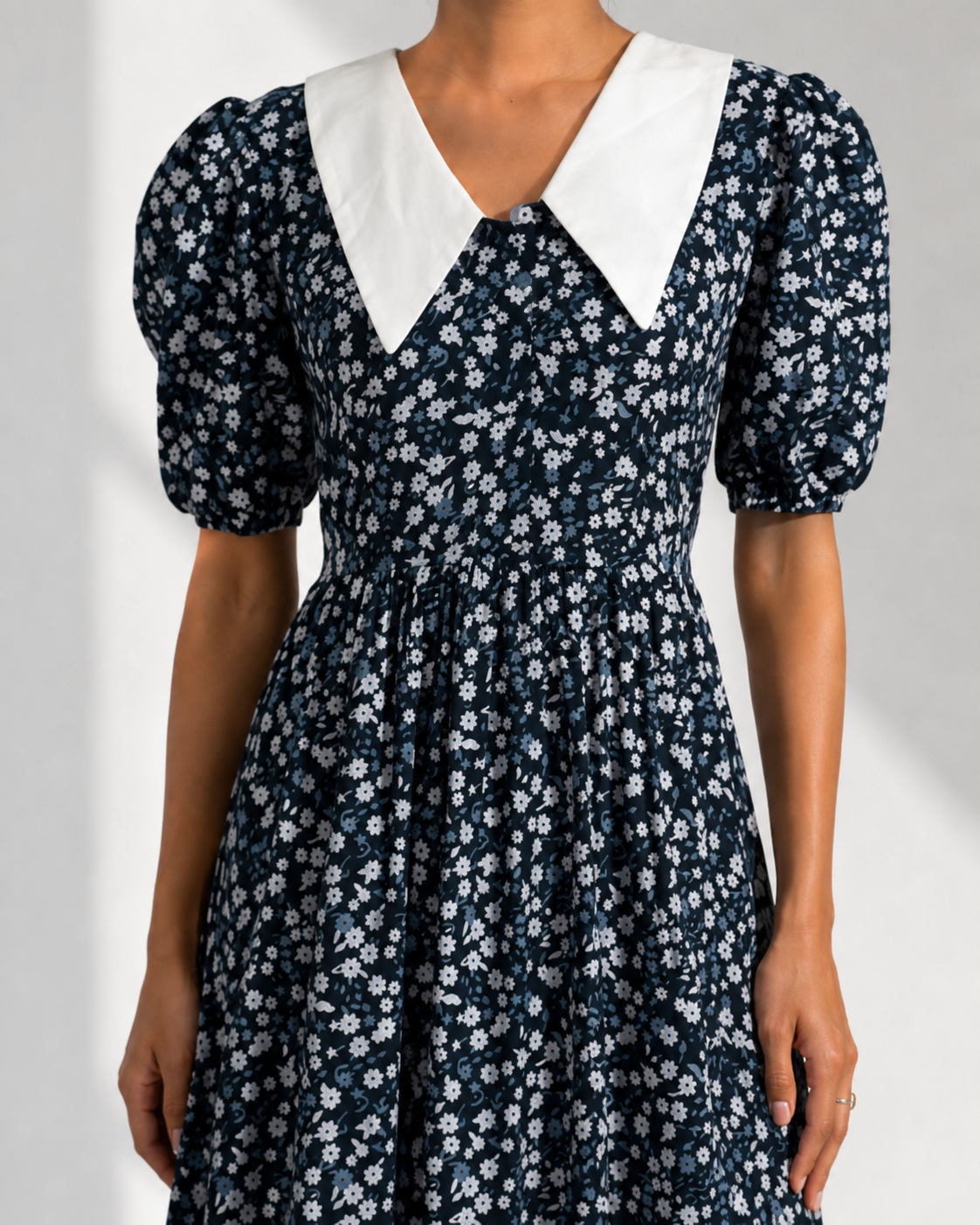Close view of the oversized white pointed collar and puff sleeve on the EULALIE navy dress.