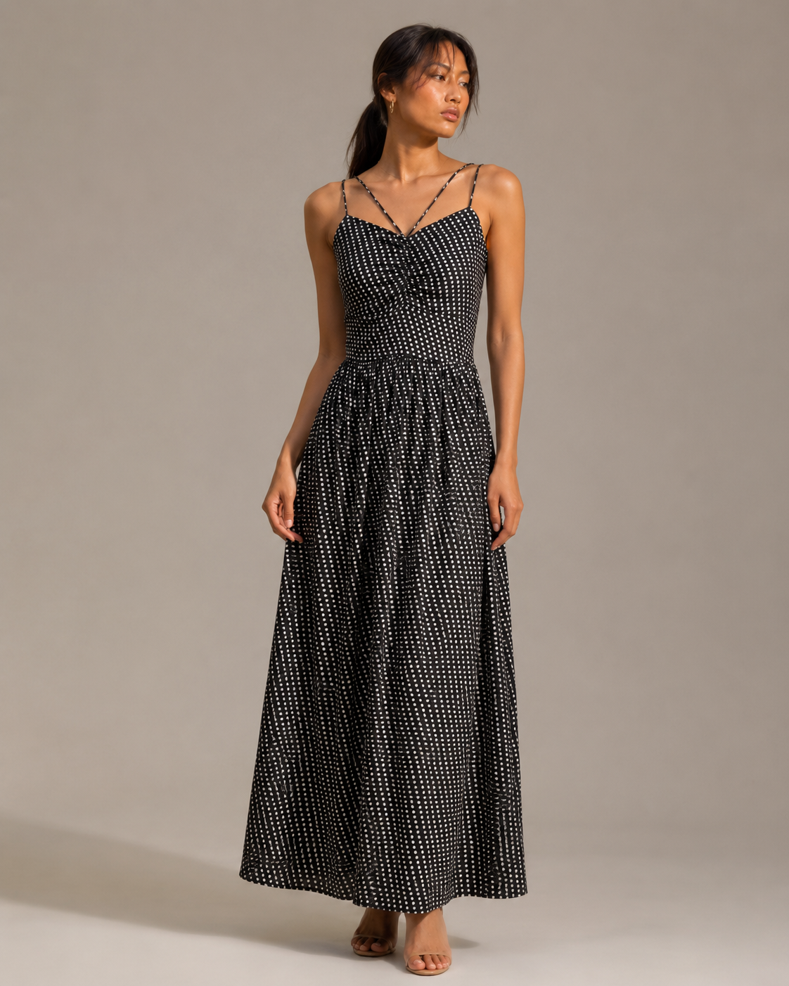 Model wearing NOVA black polka dot strappy maxi dress by Neha Sharma Label.