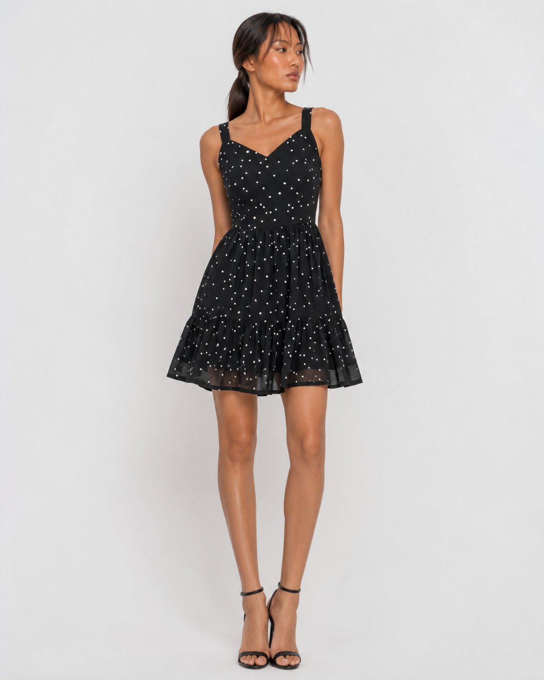 Model wearing VERA black polka dot tiered mini dress by Neha Sharma Label.