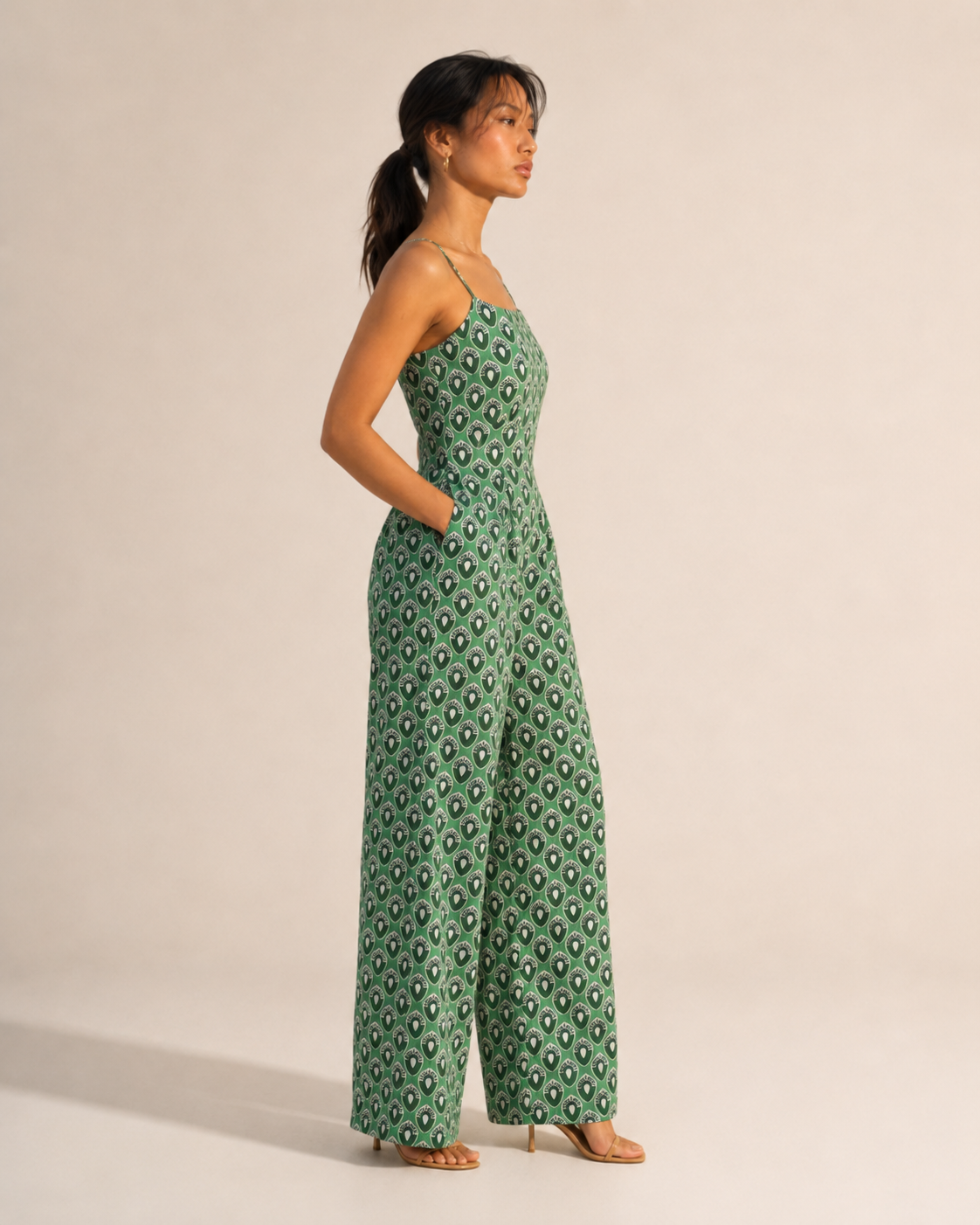 WREN green jumpsuit with straight neckline, fitted bodice and hands in the side pockets.