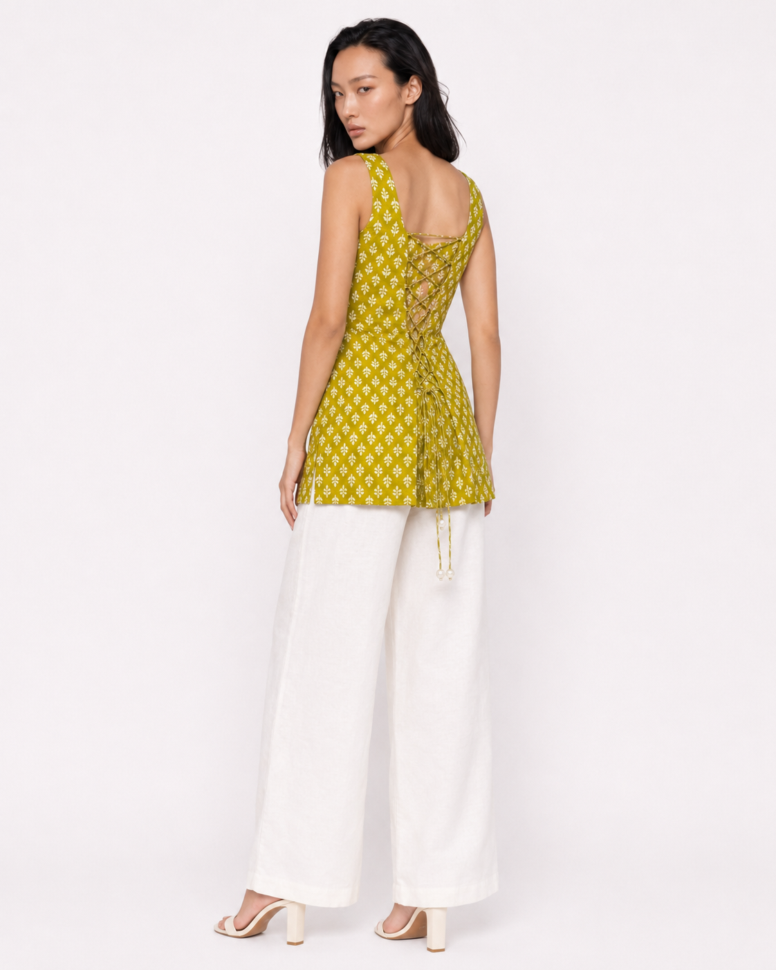 Model wearing MAHRU olive sprig print kurti showing functional tie-up dori back with pearl-tipped ties by Neha Sharma Label - back view