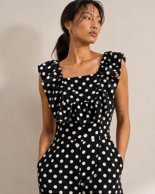 Side view of the ISLA polka dot jumpsuit with hand in the side pocket.