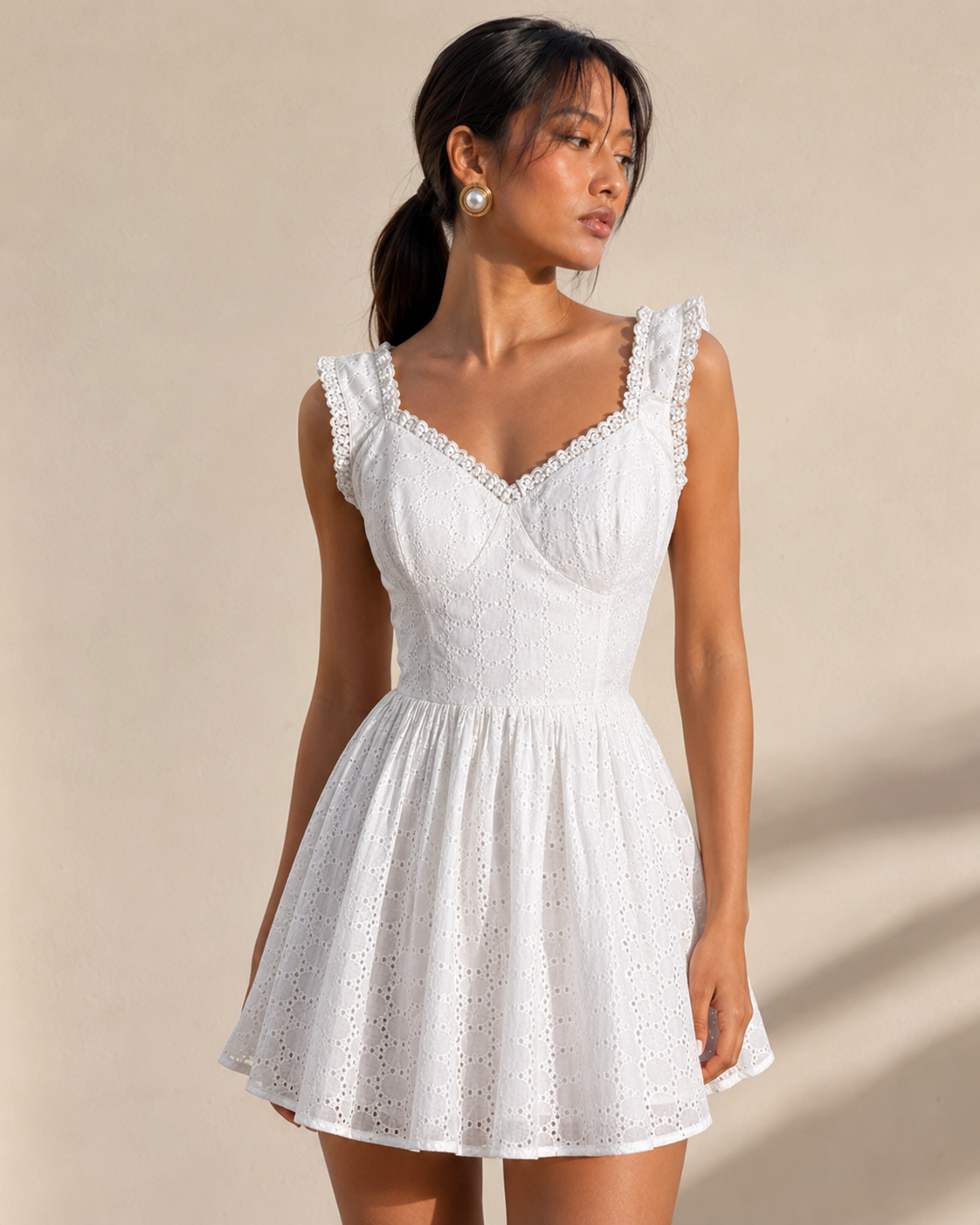 Model wearing ALBA white broderie eyelet mini dress by Neha Sharma Label.