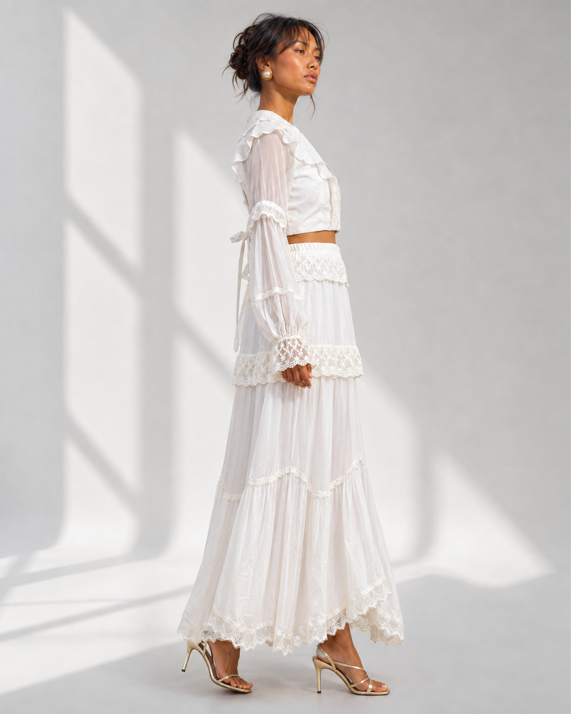 MORWENNA ivory lace co-ord set in profile with sheer blouson sleeves and tiered skirt.