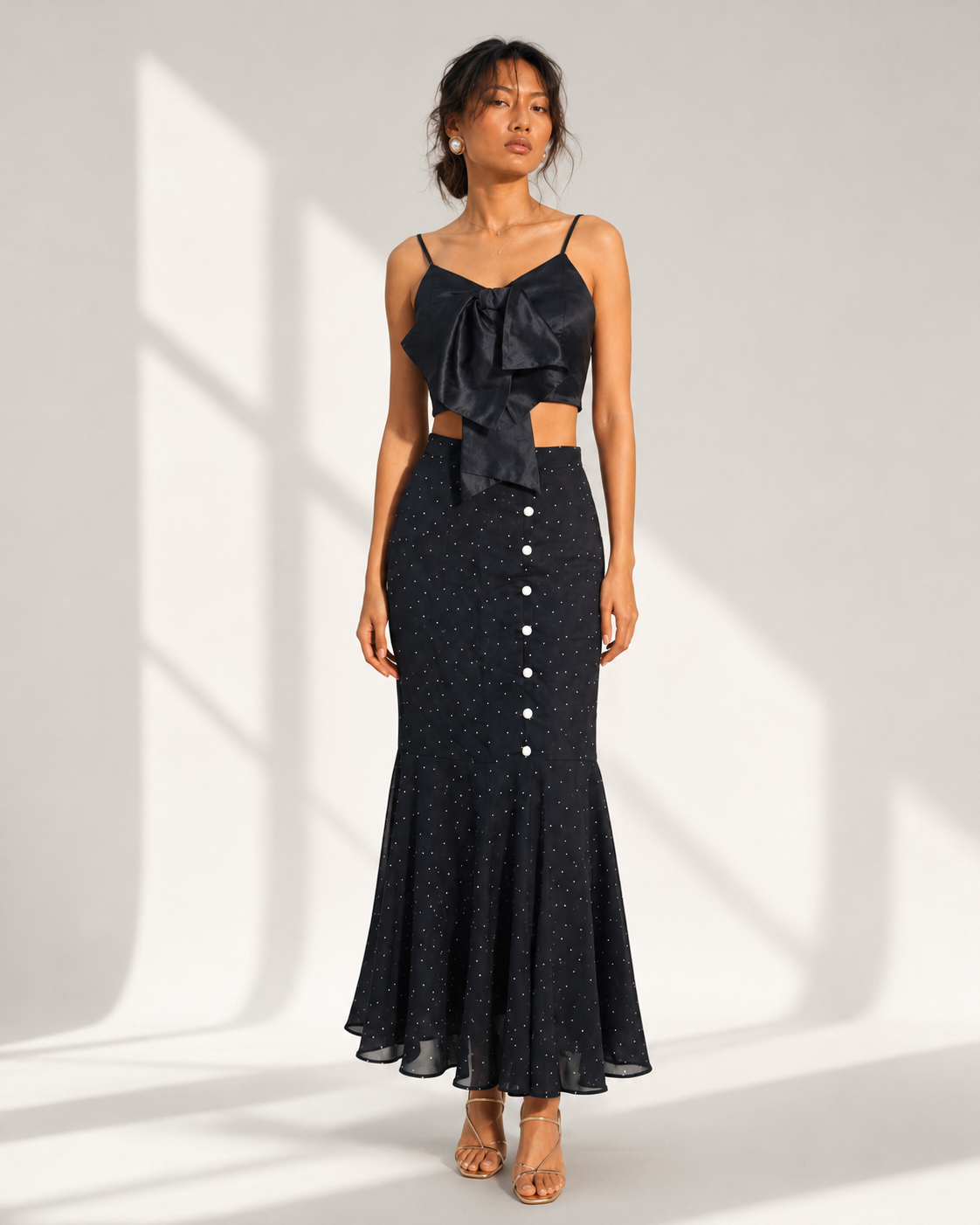 Neha Sharma Label FIAMMETTA black co-ord with bow cami and dot mermaid skirt, front view.