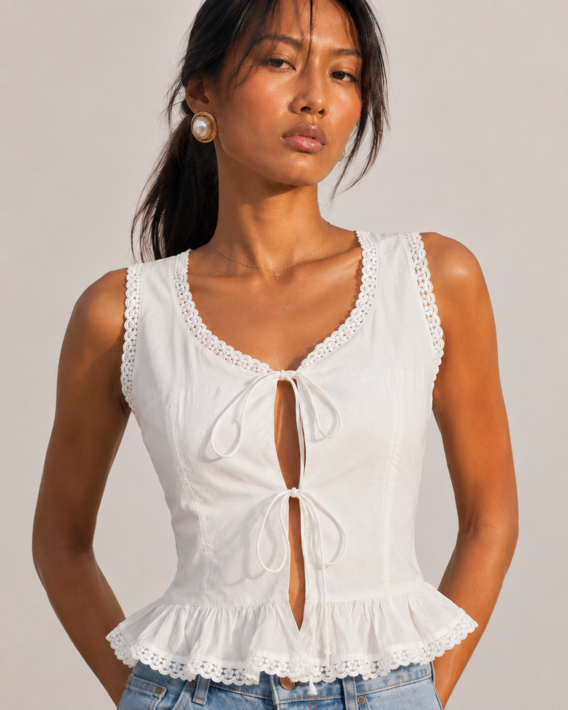 Detail of the lace edging and peplum flounce hem on the MARGOT white top.