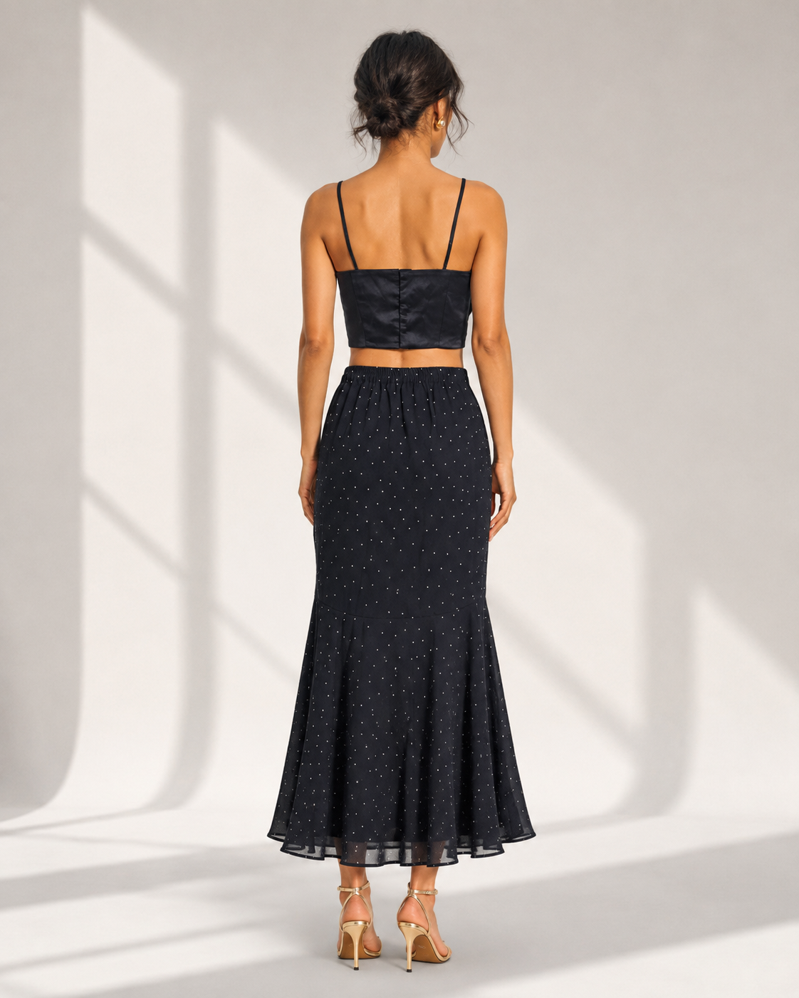 Back view of the FIAMMETTA black co-ord showing the fitted cami back and elasticated skirt waist.