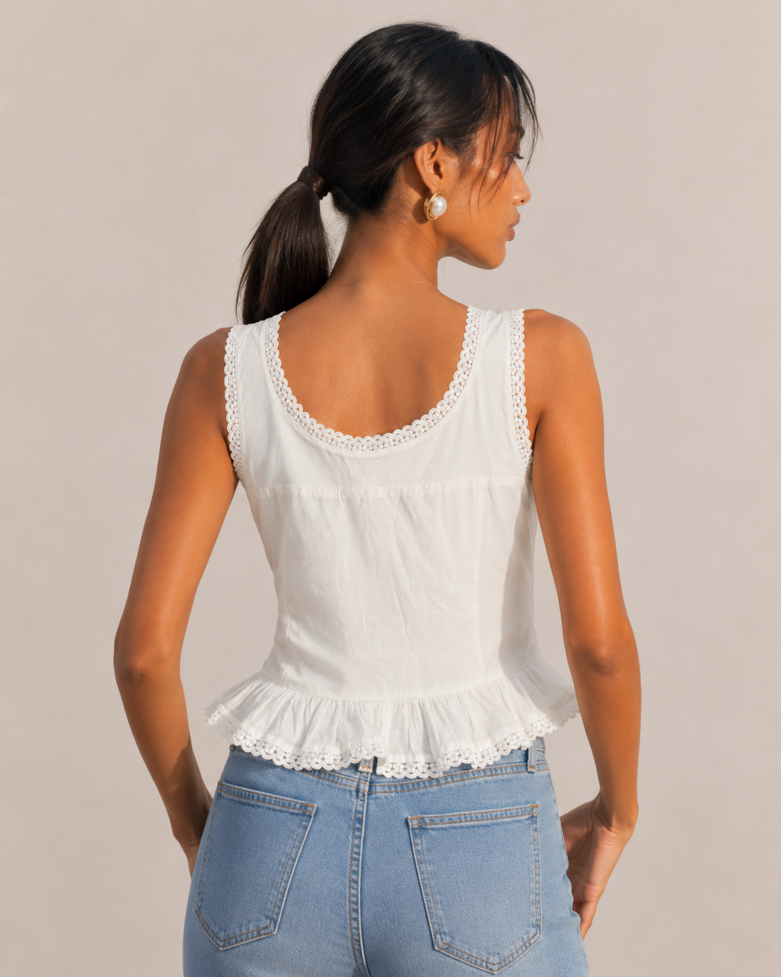Back view of the MARGOT white peplum top showing the lace-trimmed scoop back.