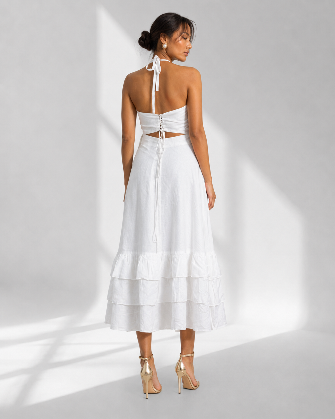 Back view of the MAREVA white halter dress showing the tie back and open back.