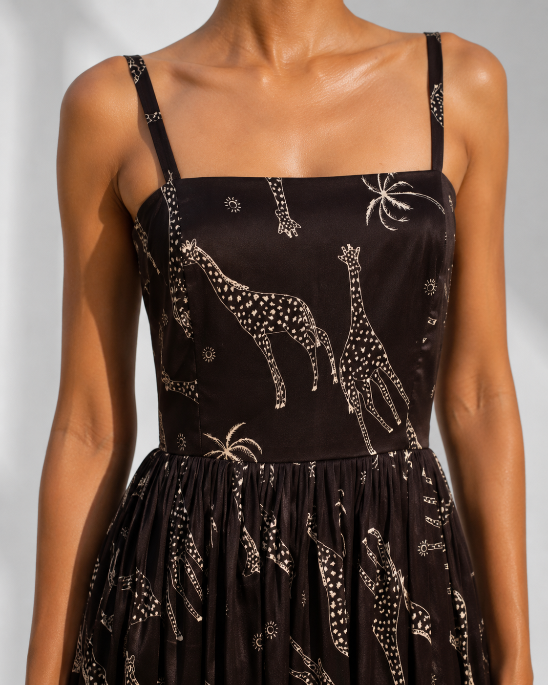Close view of champagne giraffe and palm print across the fitted satin bodice of the NYALA dress.